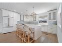 Kitchen features a large island with seating, lovely pendant lights, and stainless steel appliances at 108 5Th Ave, St Pete Beach, FL 33706