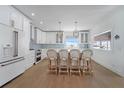 Bright, stylish kitchen featuring white cabinets, wood floors, island with seating, and stunning view from the window at 108 5Th Ave, St Pete Beach, FL 33706