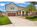 Traditional two-story home with a two-car garage, covered porch with rocking chairs at 11024 Purple Martin Blvd, Riverview, FL 33579