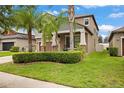 Suburban home showcasing a lush lawn, manicured landscaping, and a covered front porch at 11024 Purple Martin Blvd, Riverview, FL 33579