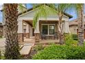 Inviting covered porch featuring classic rocking chairs, brick accents, and fresh landscaping at 11024 Purple Martin Blvd, Riverview, FL 33579