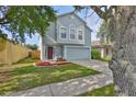 Charming light blue two-story home with a well-manicured lawn and an attached two-car garage at 11438 Ivy Flower Loop, Riverview, FL 33578