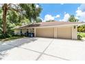 Spacious home featuring an attached garage with two bays and a large concrete driveway surrounded by lush greenery at 11945 Darwin Ave, New Port Richey, FL 34654
