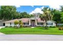 Charming single-story home with manicured lawn and mature landscaping, plus double front doors at 11945 Darwin Ave, New Port Richey, FL 34654