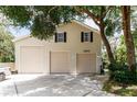 Spacious garage with multiple bays and an upper level, shaded by mature trees at 11945 Darwin Ave, New Port Richey, FL 34654