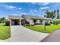 Charming single-story home with a well-manicured lawn, mature landscaping, and a covered carport at 123 Glendower Cir # 123, Sun City Center, FL 33573