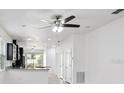 Spacious living space featuring neutral paint, modern ceiling fan, and a pass-through to the kitchen at 1325 Custer Bayou St, Ruskin, FL 33570