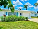 This home features a lush green lawn and tasteful landscaping, enhancing its curb appeal beneath a bright, sunny sky at 14230 86Th Ter, Seminole, FL 33776