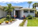 Stunning home's front entrance is accentuated with vibrant landscaping and a paved walkway at 14422 Chamberlain Blvd, Port Charlotte, FL 33953