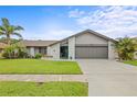Charming home with a well-manicured lawn, lush landscaping, and a two-car garage at 1632 Ridge Top Way, Clearwater, FL 33765