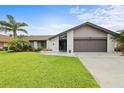Charming single-story home with well-manicured lawn, tropical landscaping, and two-car garage at 1632 Ridge Top Way, Clearwater, FL 33765