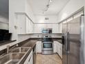 Well-lit kitchen featuring stainless steel appliances, tiled floors, and bright white cabinetry at 2010 E Palm Ave # 14303, Tampa, FL 33605
