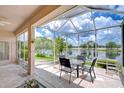 Relaxing screened patio overlooking a serene lake with seating for four, perfect for outdoor dining at 2226 N Creek Ct, Sun City Center, FL 33573
