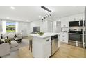 Open concept living space with kitchen island, modern lighting, and cozy seating arrangement at 4220 E Regnas Ave, Tampa, FL 33617