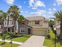 Beautiful two-story home with stone accents, palm trees and a brick driveway at 4544 Vermillion Sky Dr, Wesley Chapel, FL 33544