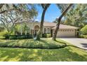 Beautiful single-story home with lush landscaping, mature trees, and a well-maintained lawn at 5804 Terncrest Dr, Lithia, FL 33547