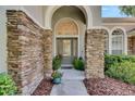 Inviting front entrance with stone accents, arched doorway, and decorative glass door at 5804 Terncrest Dr, Lithia, FL 33547