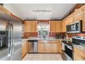Well-equipped kitchen featuring stainless steel appliances and warm-toned wood cabinetry at 5908 Mohr Rd, Tampa, FL 33615
