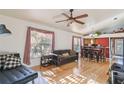 Sunlit living room with hardwood floors, a ceiling fan, and a view to the kitchen area at 5908 Mohr Rd, Tampa, FL 33615