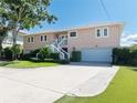 Charming two-story home with landscaped yard, featuring a staircase leading to the front door and a driveway at 6663 Bayou Grande Ne Blvd, St Petersburg, FL 33702