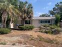 Single story home with a lawn featuring mature palms and a traditional, symmetrical facade at 7519 Kensico Dr, Port Richey, FL 34668