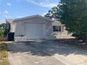 A one car garage with ample parking space on a sunny day at 7519 Kensico Dr, Port Richey, FL 34668