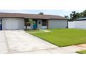 Beautiful home featuring fresh landscaping, vibrant lawn, and a driveway leading to the attached garage at 7909 Woodgrove Cir, Tampa, FL 33615