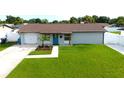 Picture of a freshly landscaped front yard with a well-maintained lawn and light grey single story house at 7909 Woodgrove Cir, Tampa, FL 33615