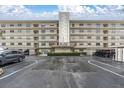 Exterior shot of a multi-story condo building featuring a well-maintained parking area and landscaping at 8198 Terrace Garden Dr # 511, St Petersburg, FL 33709