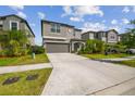 Attractive two-story home with a gray exterior, well-maintained lawn, and an extended driveway at 9440 Lemon Drop Loop, Sun City Center, FL 33573