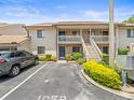 Exterior shot of a condo with parking and stairs leading to upper units at 9804 Lombard Ct # 104, Tampa, FL 33618