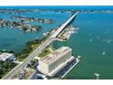 Aerial view of complex, bridge, and bay surrounded by lush neighborhoods with waterfront access at 100 Bluff View Dr # 308A, Belleair Bluffs, FL 33770