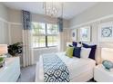 Inviting bedroom with a large window, stylish curtains, and a comfortable queen-sized bed with decorative pillows at 10586 Buttercup Ct, Venice, FL 34293