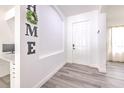 Inviting foyer featuring light gray floors and a modern workstation, enhanced by the charming 'HOME' decor at 11336 Callaway Pond Dr, Riverview, FL 33579