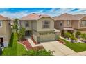Two-story home featuring a two-car garage, manicured lawn, and beautiful landscaping at 12121 Tree Haven Ave, Gibsonton, FL 33534