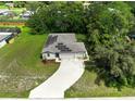 An aerial view of a house with solar panels on the roof, a long driveway, and large front and back yards at 12277 Spring Hill Dr, Spring Hill, FL 34609