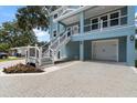 Side exterior view showcasing staircase, the driveway, and garage of the charming home at 132 Pennsylvania Ave, Palm Harbor, FL 34683
