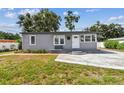 The exterior of the home features gray siding, a white door and well-maintained landscaping at 1510 W Powhatan Ave, Tampa, FL 33603