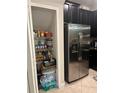 Walk in pantry with shelving next to stainless steel refrigerator at 17361 Old Tobacco Rd, Lutz, FL 33558