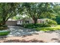 Exterior view of a charming home with a two-car garage and mature trees and shrubbery at 211 60Th S Ave, St Petersburg, FL 33705