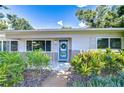 Inviting front porch with vibrant plants, a blue door, and clear house numbers for easy identification at 2201 Horan S Way, Gulfport, FL 33707