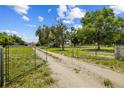 Gated entrance and long driveway leading to the home on a spacious lot with mature trees and plenty of privacy at 2221 W Lake Dr, Wimauma, FL 33598