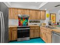 Bright kitchen features custom wood cabinets, stainless steel appliances, and a colorful backsplash at 2240 Pinewood Villas Dr, Holiday, FL 34691