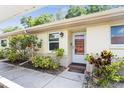 Charming condo featuring a covered entrance, lush landscaping, and a welcoming front door at 2460 Northside Dr # 708, Clearwater, FL 33761