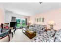 A cozy living room features a floral sofa, lamps, and a view to the outside at 2700 Bayshore Blvd # 1206, Dunedin, FL 34698