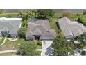 Aerial view of home featuring a screened-in pool, manicured lawn, and mature landscaping at 27826 Sora Blvd, Wesley Chapel, FL 33544