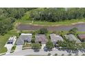 An aerial view displays the community, highlighting the home's proximity to a large pond and green spaces at 27826 Sora Blvd, Wesley Chapel, FL 33544