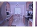 Galley kitchen with stainless steel appliances and a cozy dining area with natural light at 3200 Cove Cay Dr # 5F, Clearwater, FL 33760