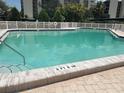 Community pool with a white fence and tiled border, ensuring a safe and enjoyable swimming experience at 3200 Cove Cay Dr # 5F, Clearwater, FL 33760