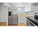 Modern kitchen with stainless steel appliances and bright white cabinets at 4326 Fern Glen St, Holiday, FL 34691